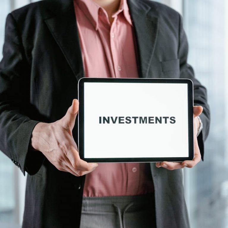 a man holding a white board with the word investments