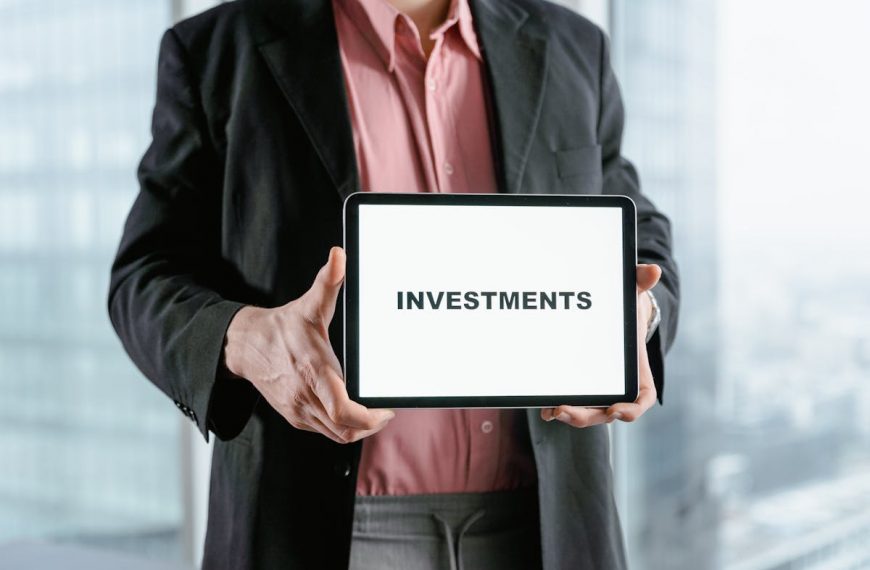 a man holding a white board with the word investments